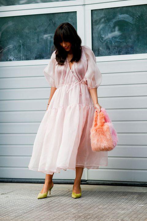 女孩穿粉色仙气薄纱连衣裙，搭配绿色尖头高跟鞋和粉色毛绒包包