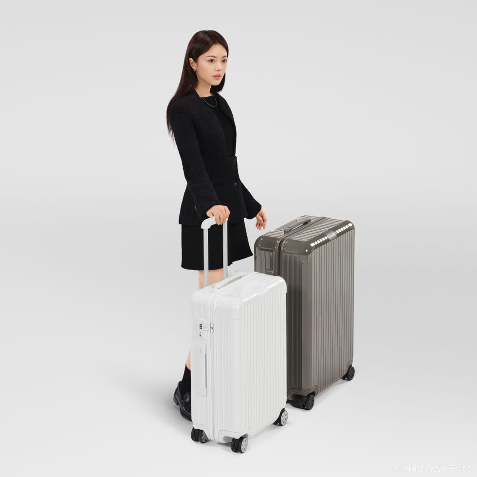 model displaying two suitcases in a minimalist setting