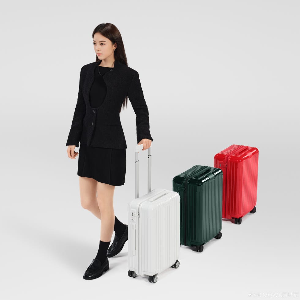 fashionable individual with luggage options in a minimalist setting