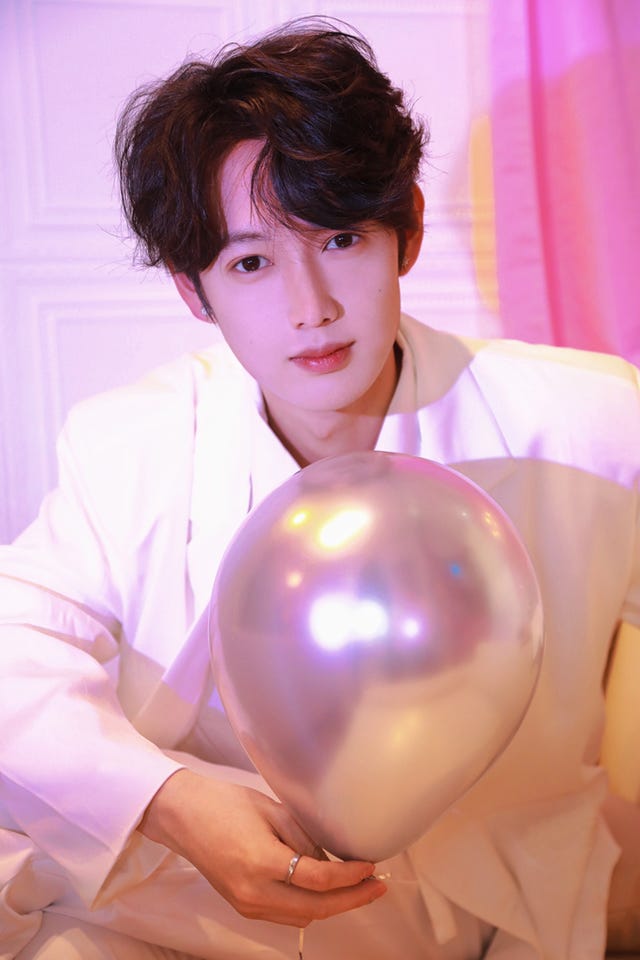 individual holding a shiny silver balloon