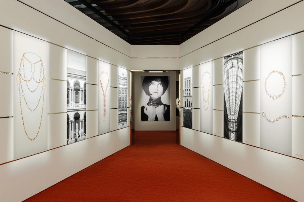 gallery showcasing jewelry art on white walls with a red carpet floor