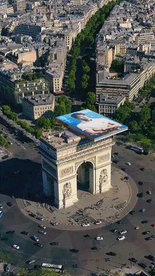 arch monument with a large advertisement on top surrounded by a circular road