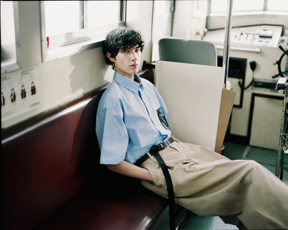a person resting on a bench in a public transportation setting