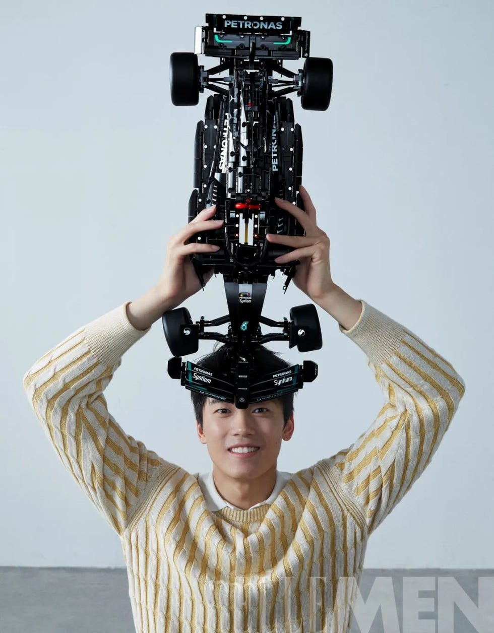 person holding a model race car above their head
