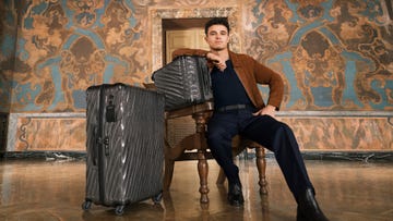 luggage arranged with a person seated beside it in an ornate setting
