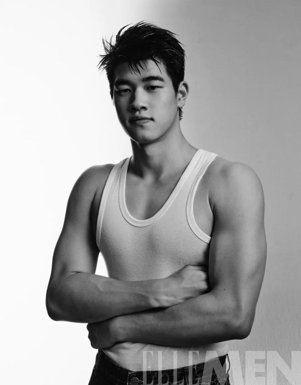 portrait of a young man in a sleeveless shirt and jeans arms crossed