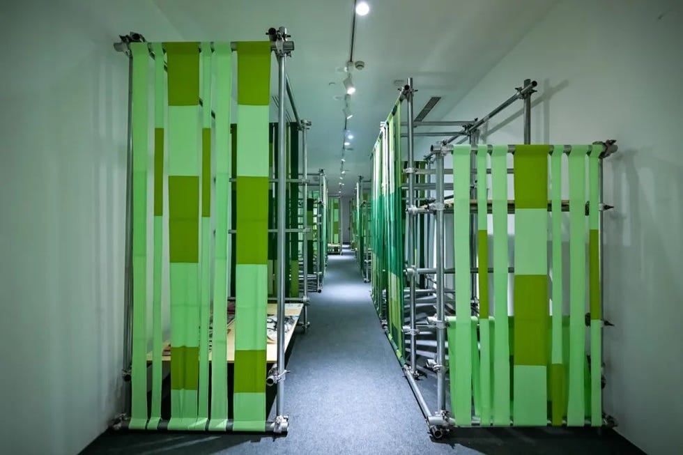 interior space featuring vertical green fabric panels arranged in a structured layout