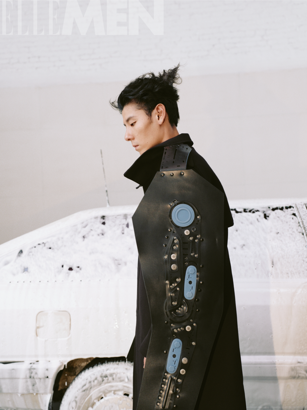 fashion model wearing a unique black garment with a mechanical arm design