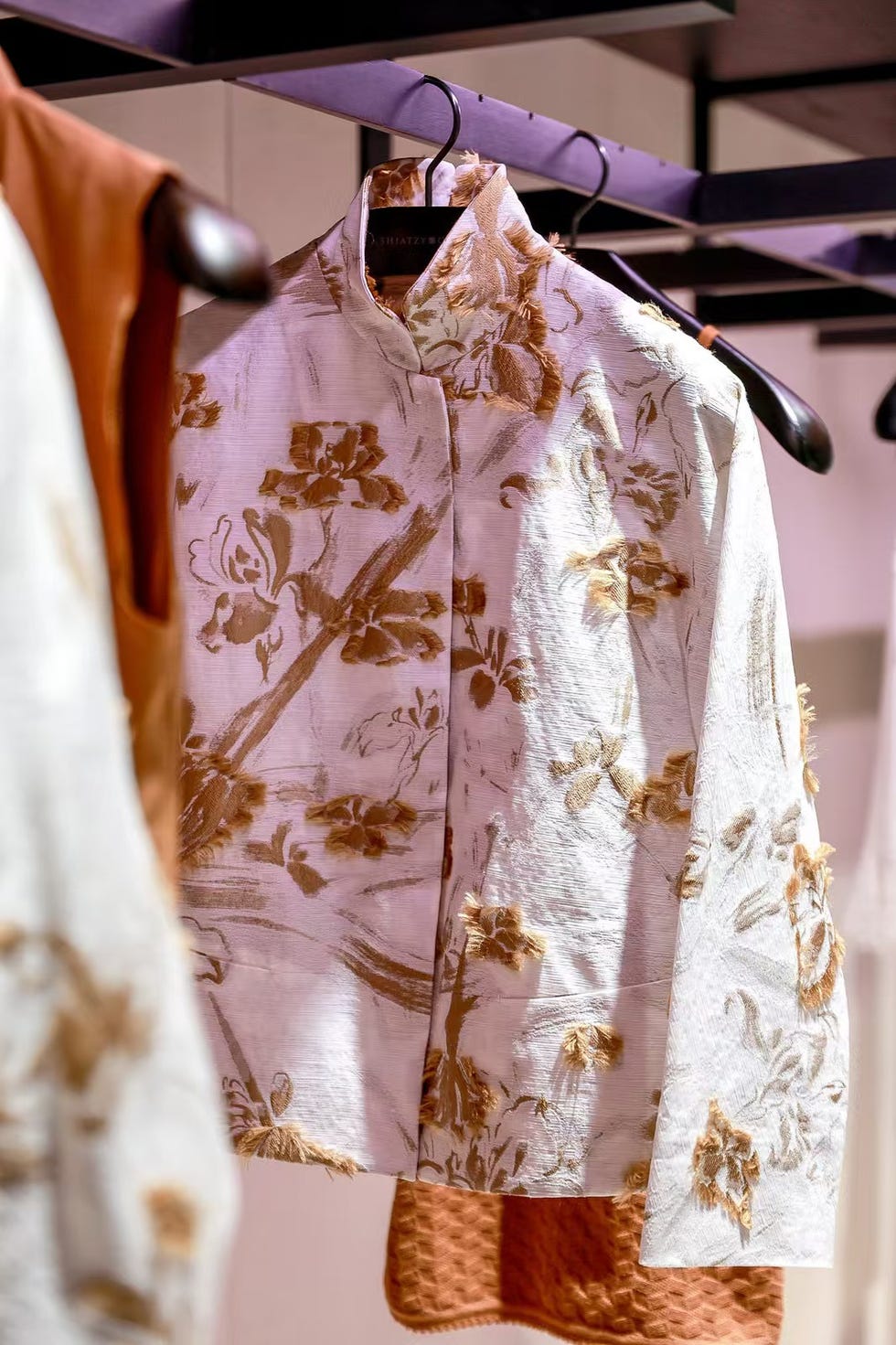 traditional garment featuring floral patterns displayed on a hanger