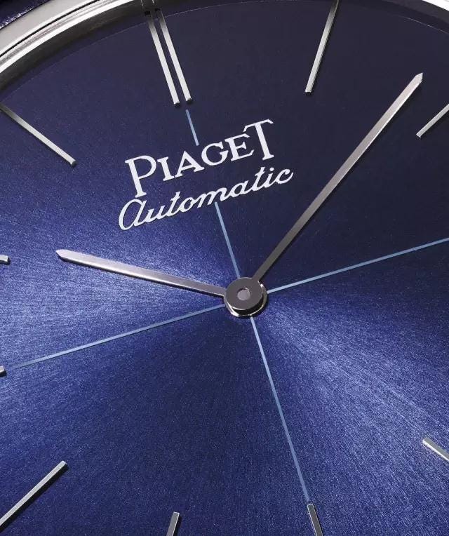Font, Watch, Electric blue, Clock, Fashion accessory, Material property, Analog watch, Brand, Space, Metal, 