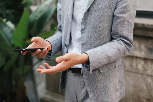 Suit, Street fashion, Hand, Finger, Outerwear, Blazer, Jacket, Formal wear, Technology, Smoking, 