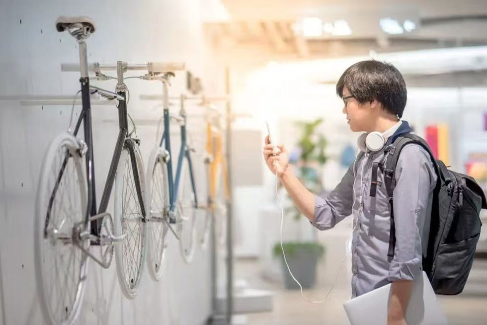 a person using a smartphone near bicycles on display