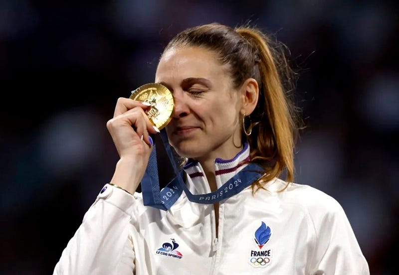a woman holding a gold medal