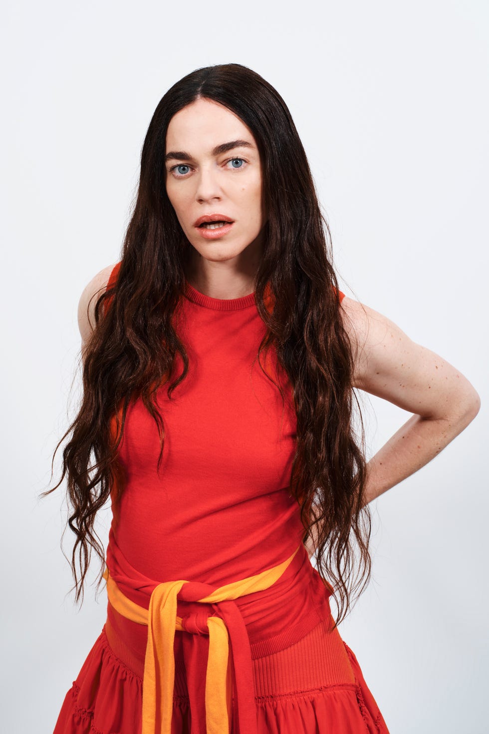 woman wearing a red outfit with long hair hands on her hips