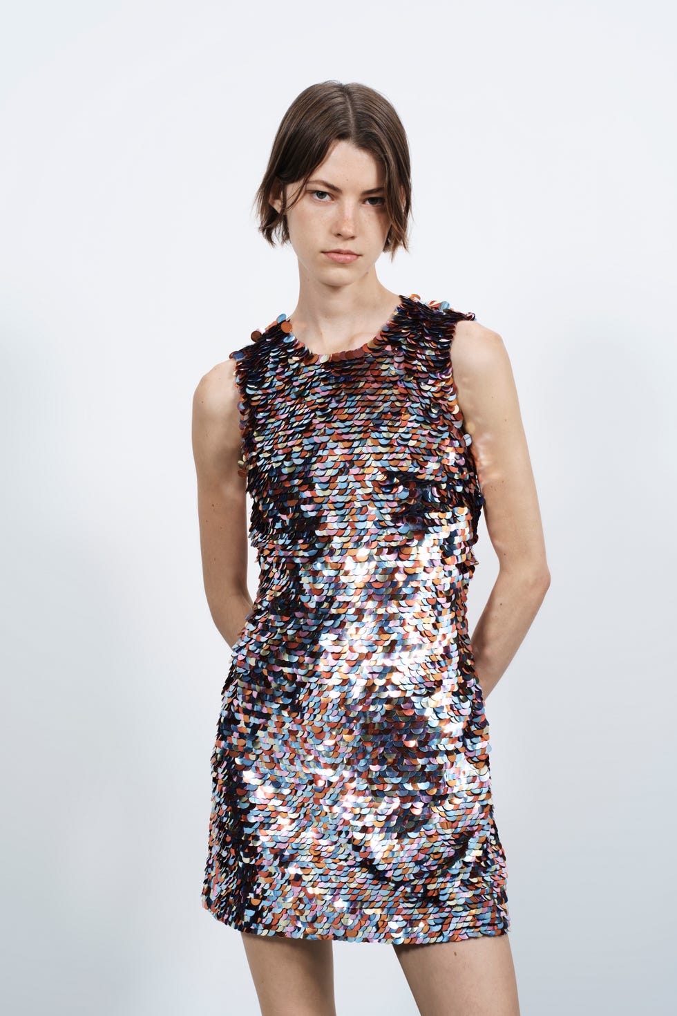 fashionable sequined dress modeled against a plain background