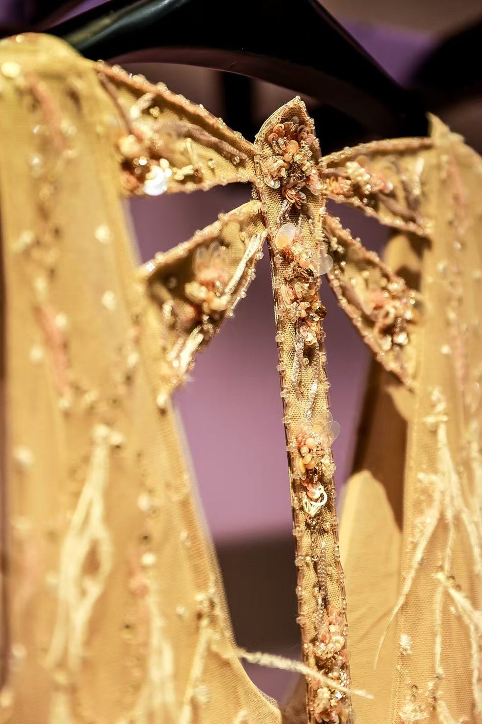 detailed closeup of an intricately designed gown displaying floral embellishments