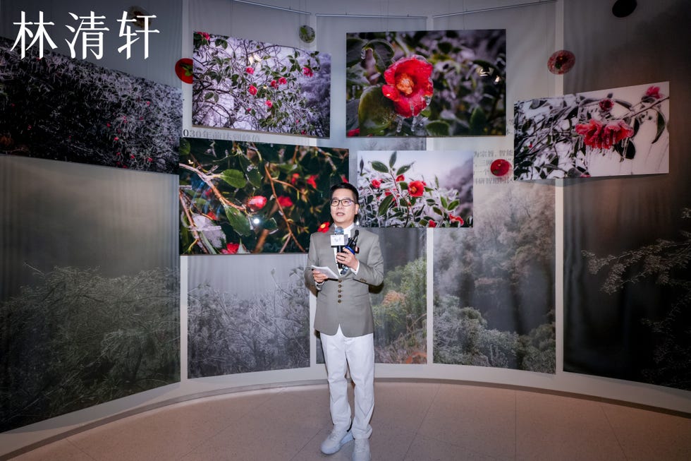 exhibition showcasing nature photography with a presenter holding a microphone
