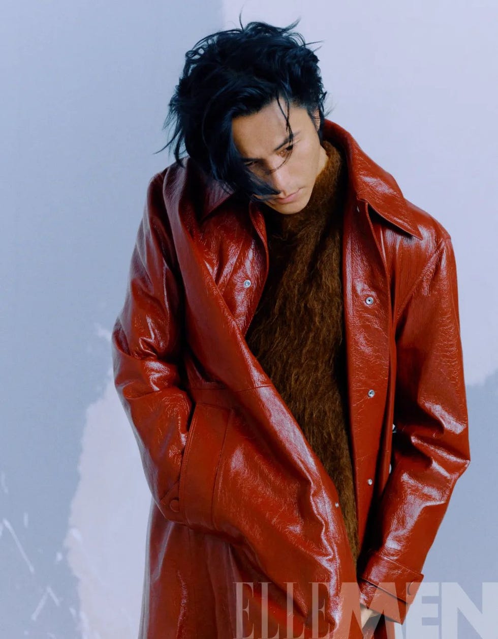 a person wearing a vibrant red leather coat with a fuzzy inner garment posing against a soft background