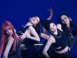 a group performance featuring multiple dancers in coordinated outfits and movements
