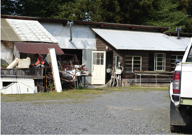 rural shed with various tools and scrap materials outside