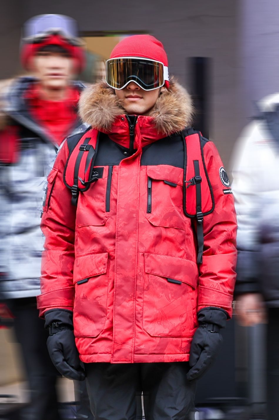 a person wearing a red coat and goggles