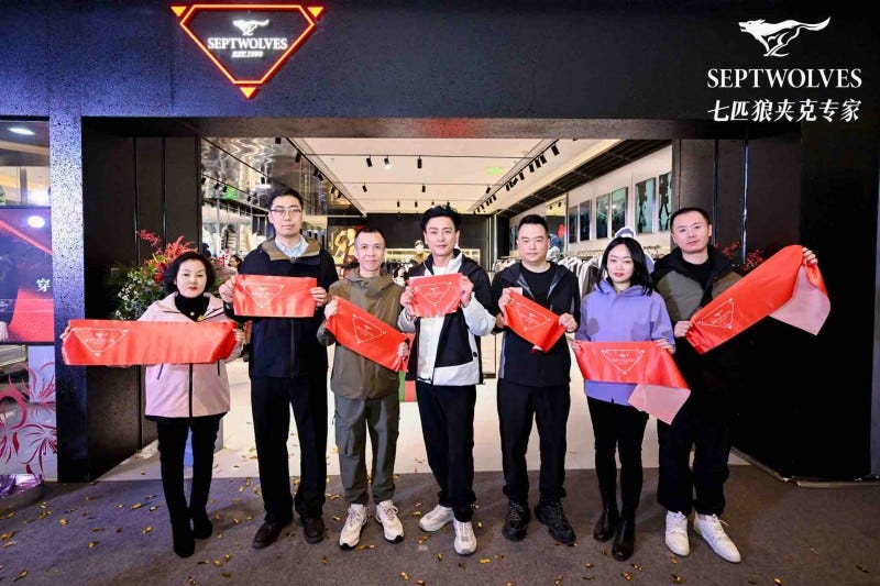 group of individuals holding red banners in front of a retail store