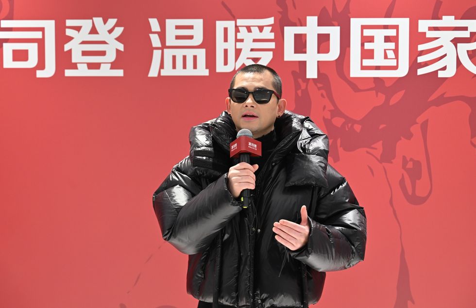 a person wearing sunglasses and holding a microphone