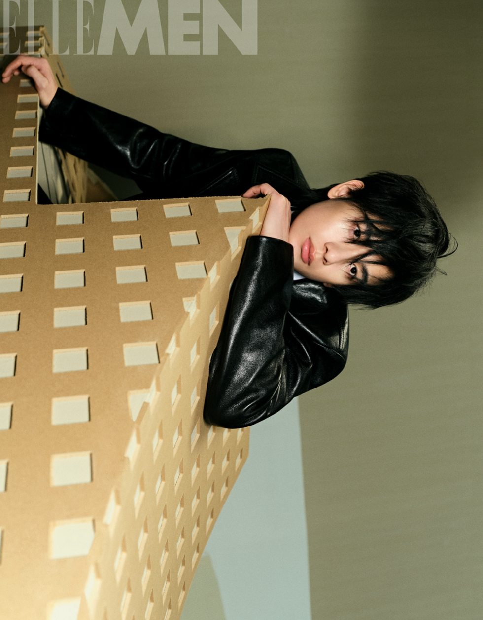 model leaning against a geometric cardboard structure