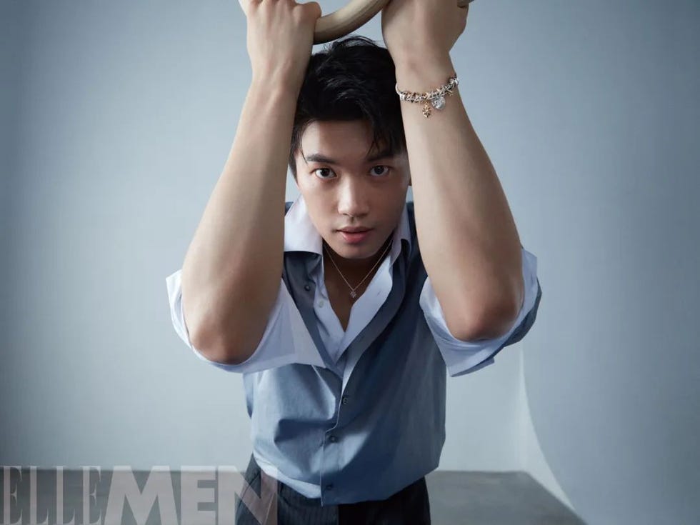 a person holding a curved object above their head against a light gray background