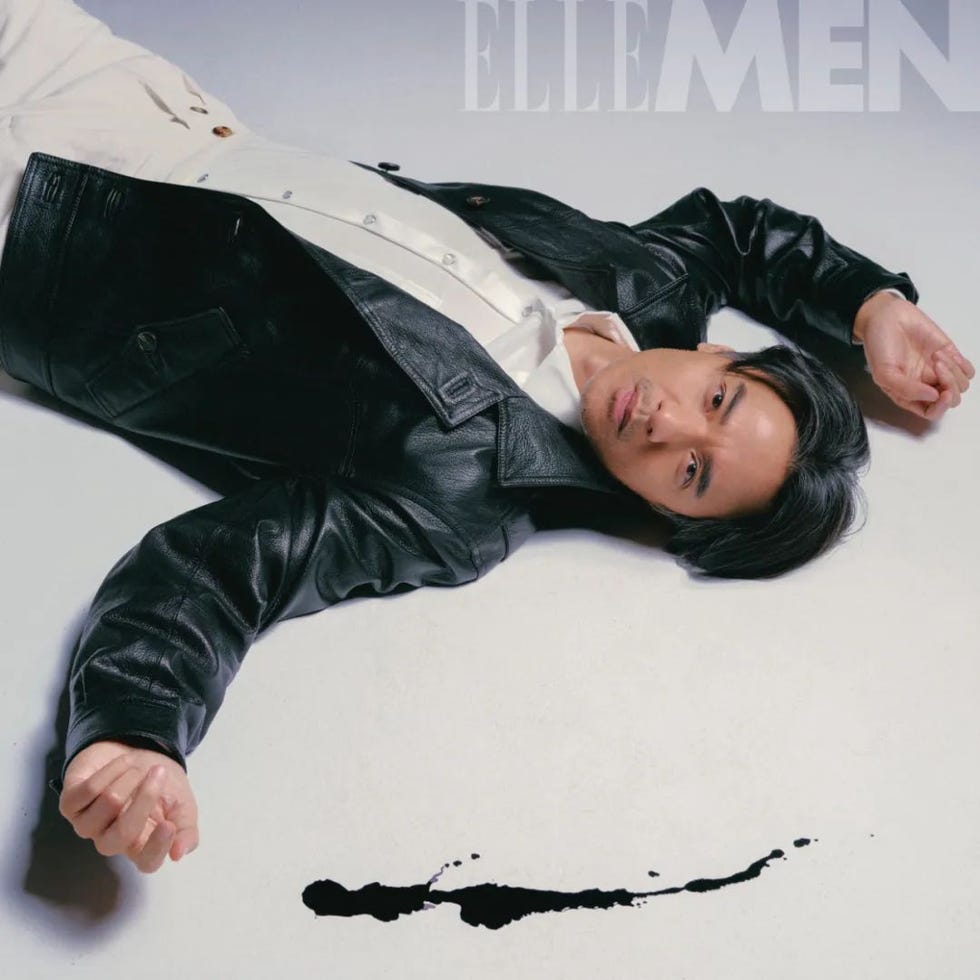 a fashion editorial featuring a person in a leather jacket and light shirt on the ground
