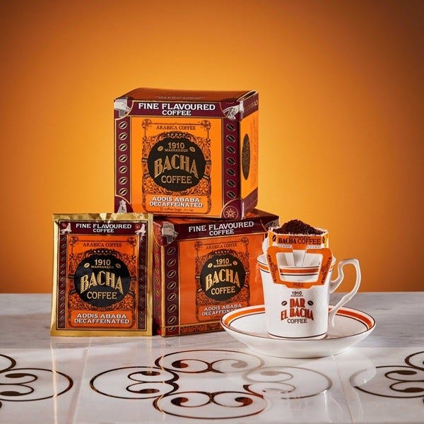 display of bacha coffee packaging and a cup with coffee grounds