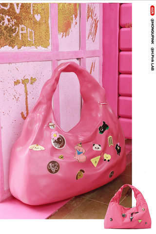 a pink handbag adorned with various colorful stickers