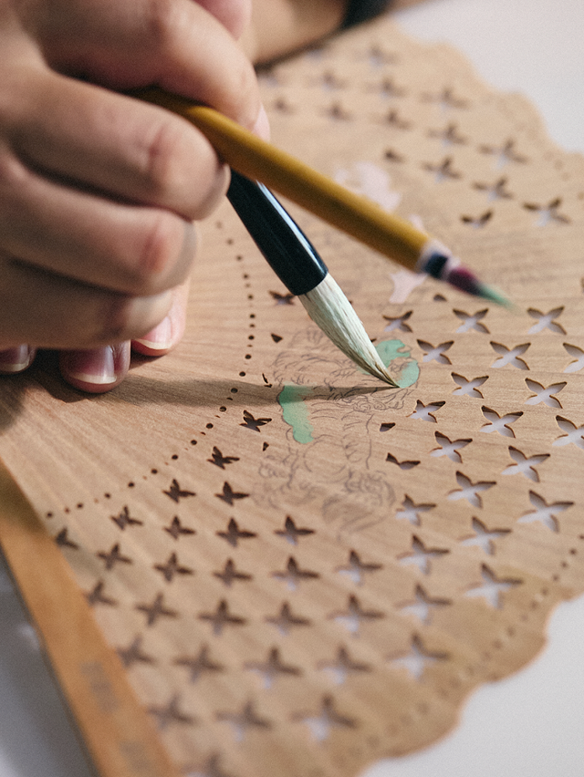 brush in use on a decorative patterned paper