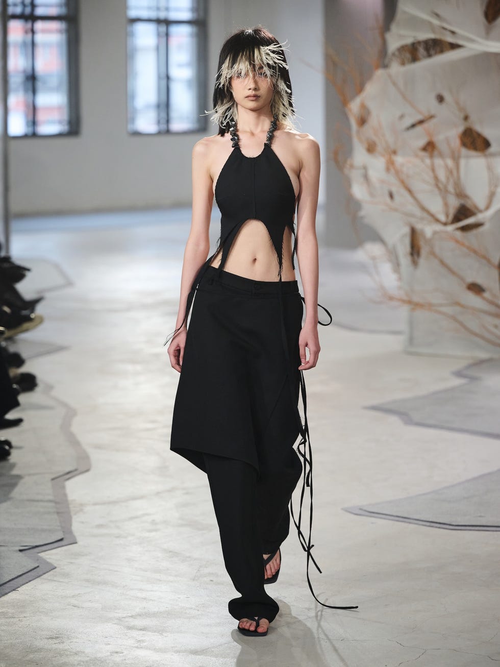 fashion runway featuring a model in a black outfit
