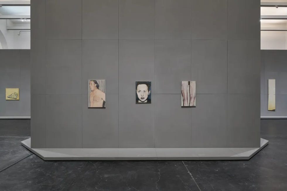 art installation featuring several framed artworks on a gray wall