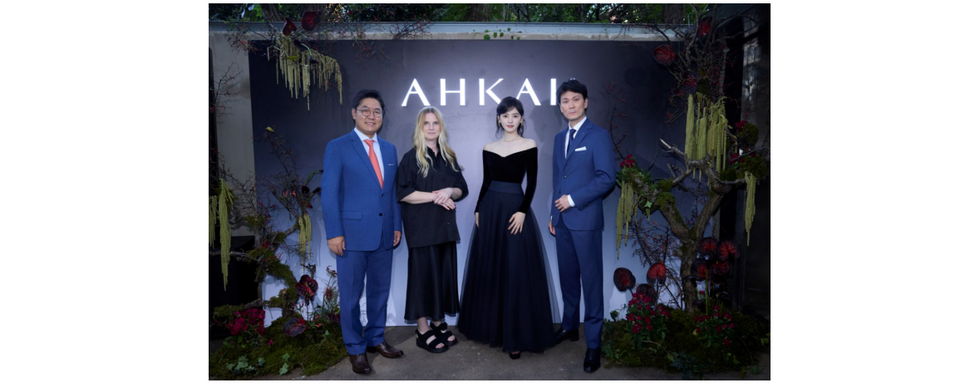 group of four individuals posing in front of a decorative backdrop with the text ahkai