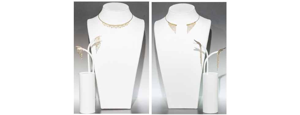 display of two sets of gold jewelry on white stands