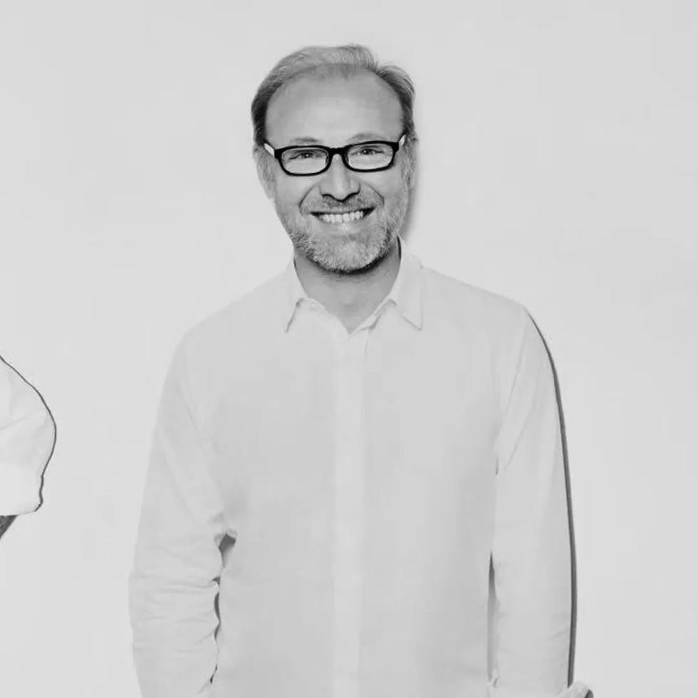 two individuals wearing white shirts with a plain background