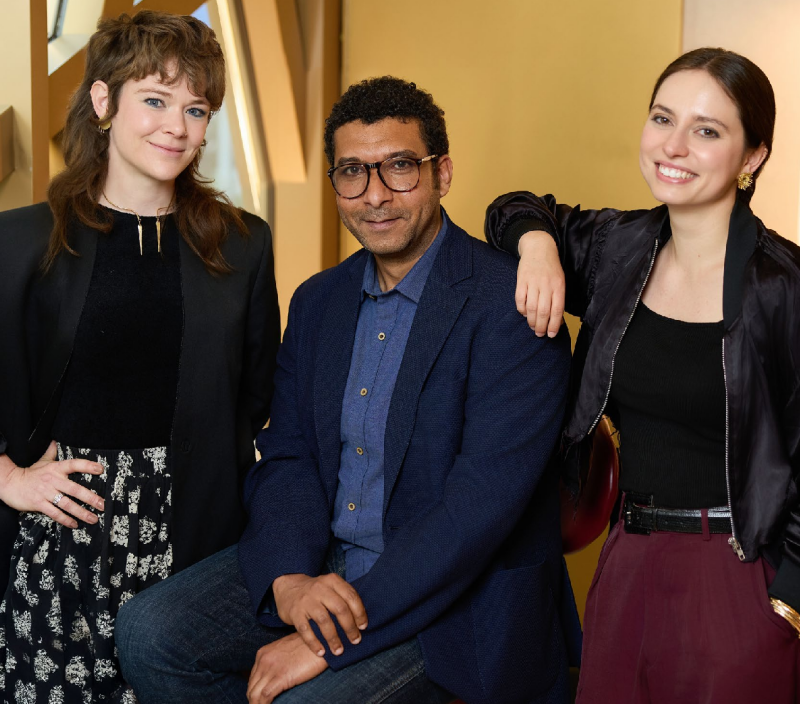 three people posing together in a stylish indoor setting