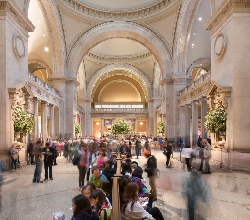 crowd in a large museum atrium with ornate architecture