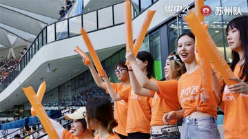 supporters cheering at an event with orange accessories
