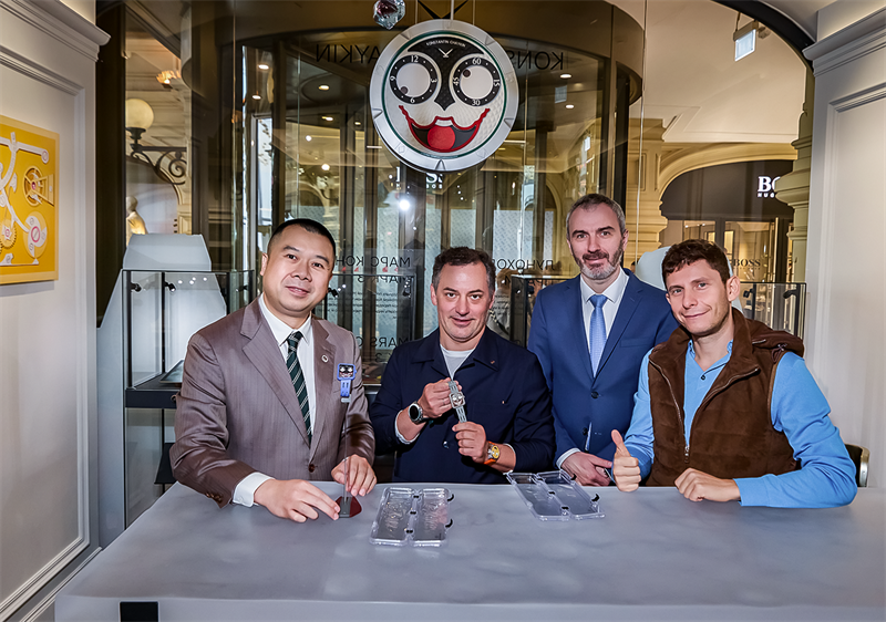 group of individuals at a display showcasing watches in a retail environment