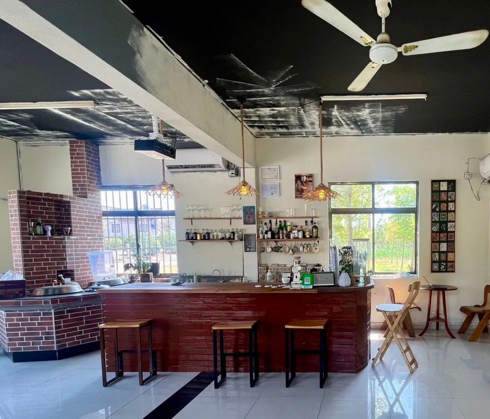 café interior featuring a bar area with stools a window and decorative shelving