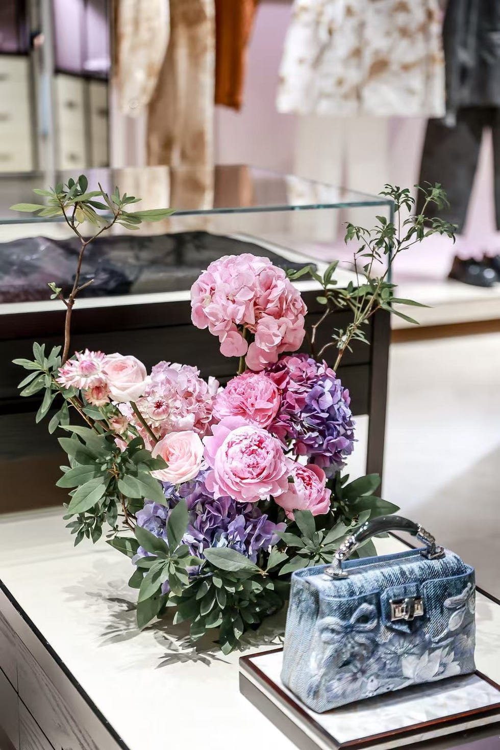 display of artificial flowers and a handbag