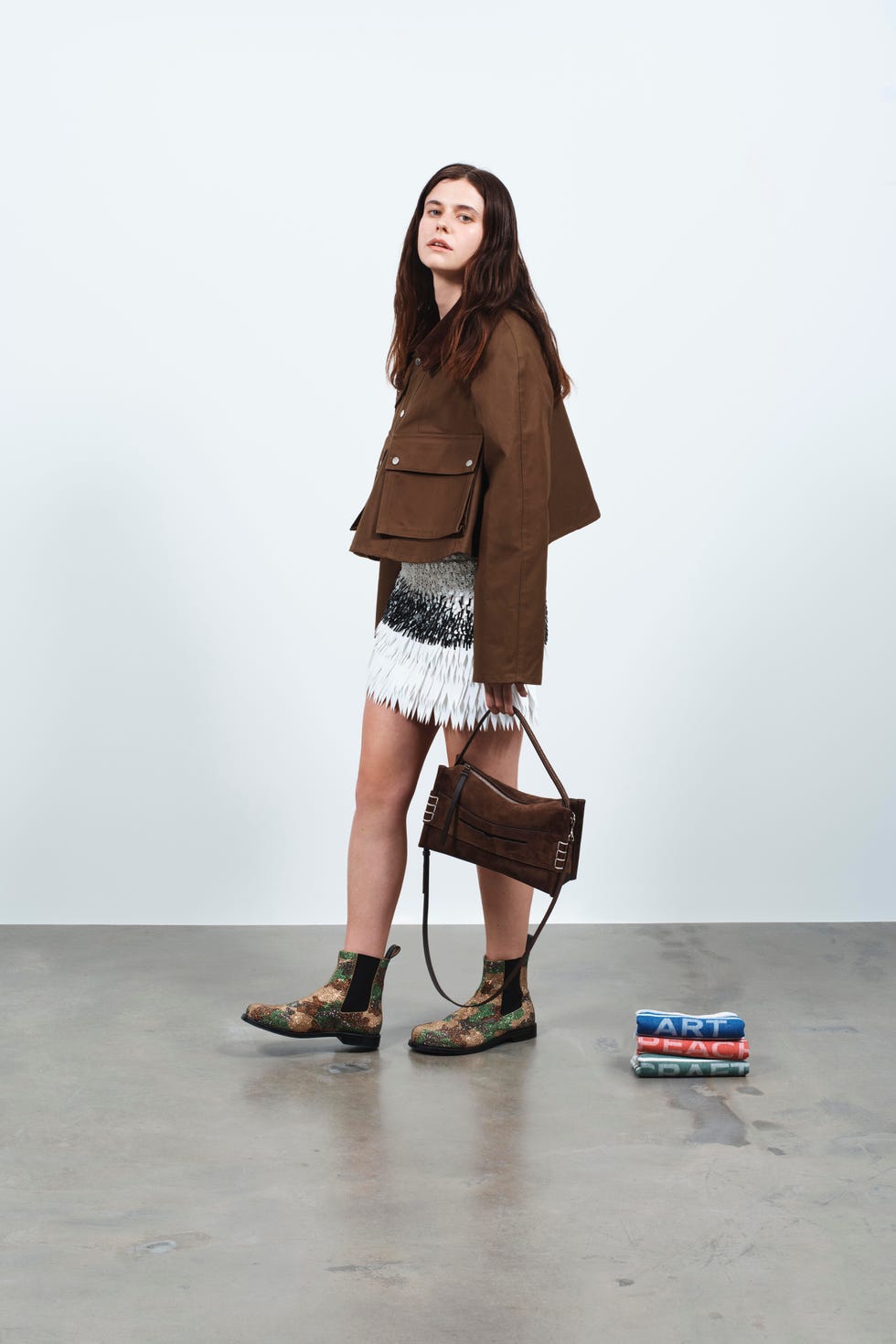 fashionable outfit featuring a brown jacket fringe skirt and stylish boots