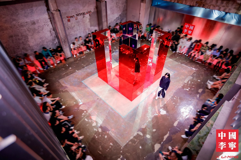 a person on a stage with a crowd watching