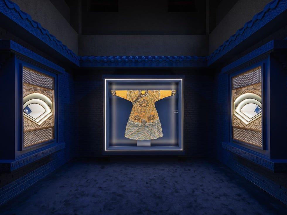 display of a traditional garment in a museum setting with illuminated background