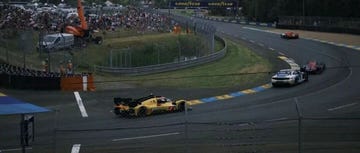 race cars competing on a track with spectators in the background