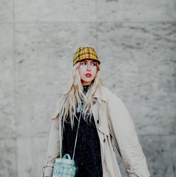 a person in a white coat and hat with a purse