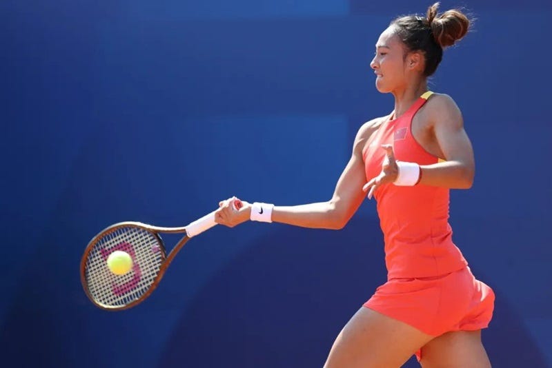 a woman hitting a ball with her tennis racket